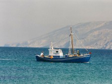 Un bateau de pêche passe devant la côte