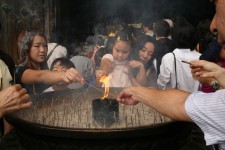 Allumage de bâtons d'encens devant un temple